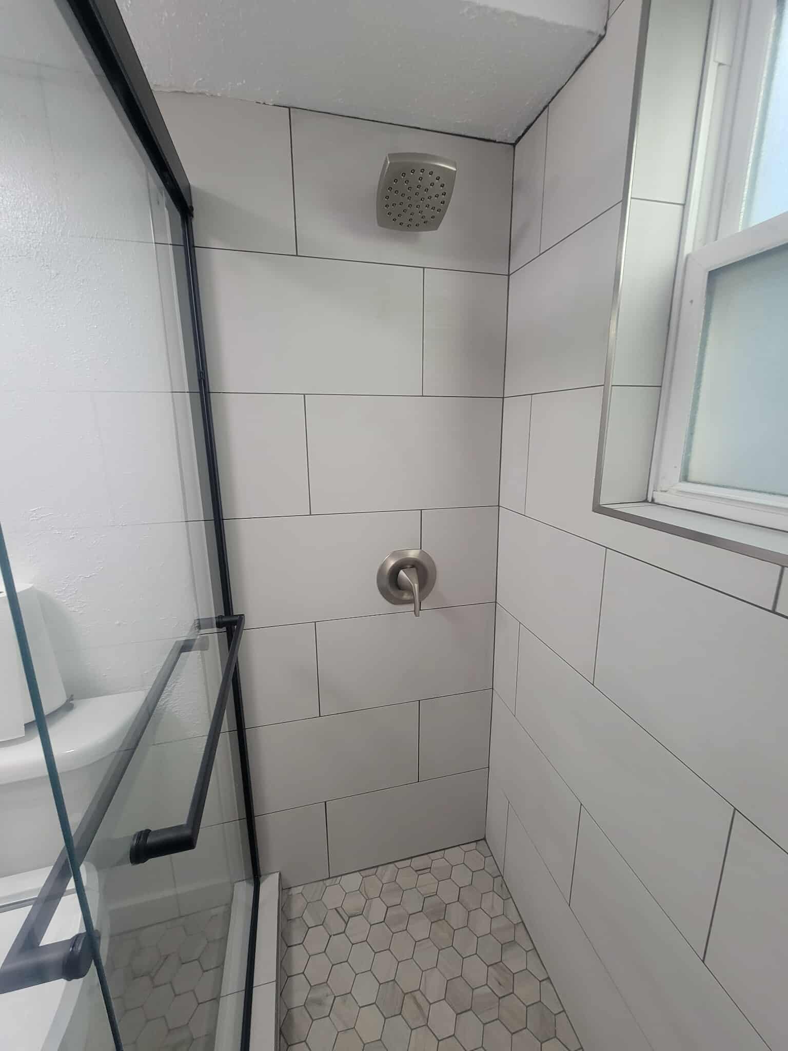 Rain shower head with white tile surround