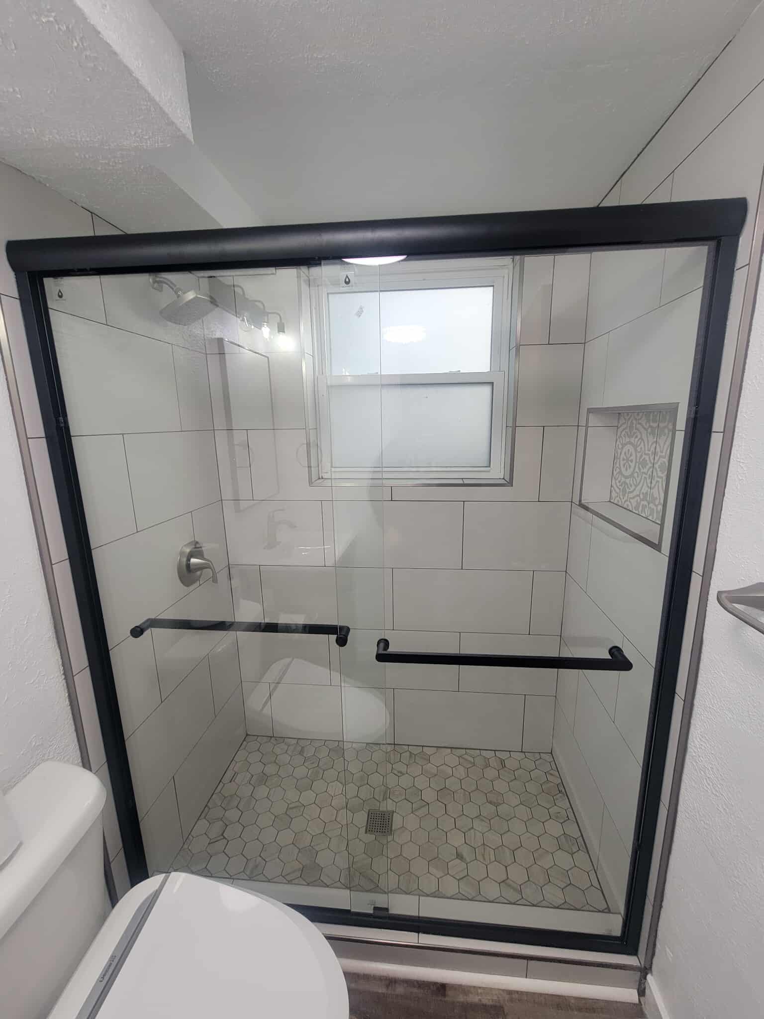 Full shower view with white tile and glass enclosure